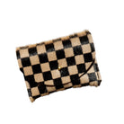 A cowhide cardholder with a black and tan checkerboard pattern and a small gold snap button, shown on a plain white background.