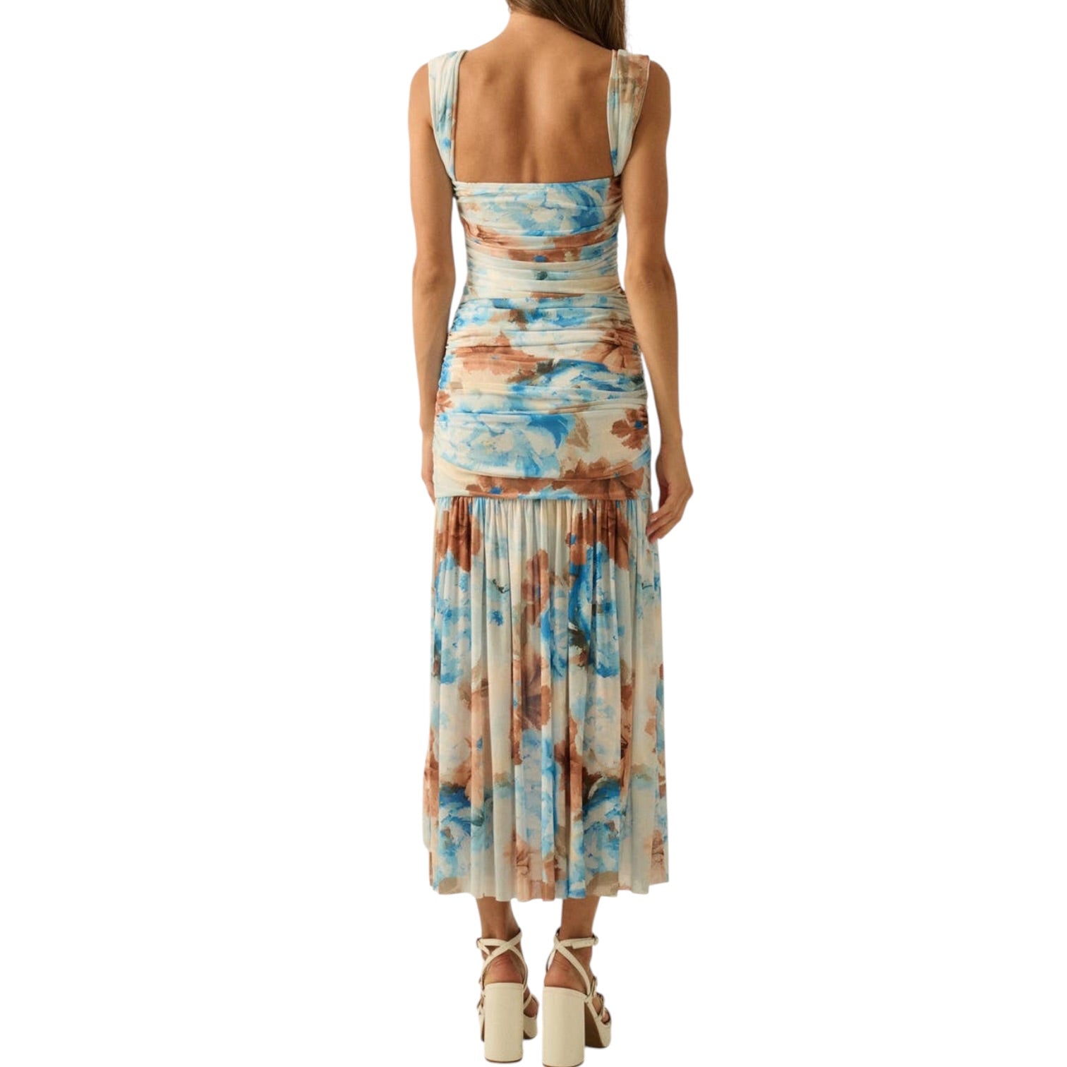 Woman wearing a sleeveless dress with a floral pattern on a white background