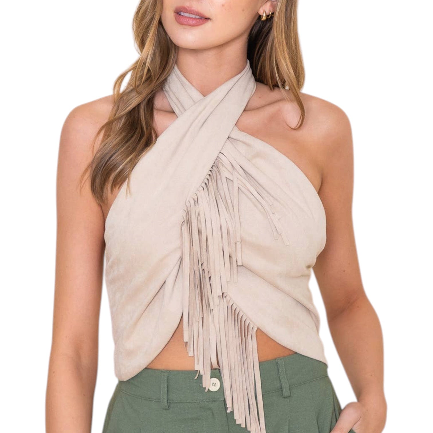 Woman wearing a beige fringe halter top with green pants on a white background