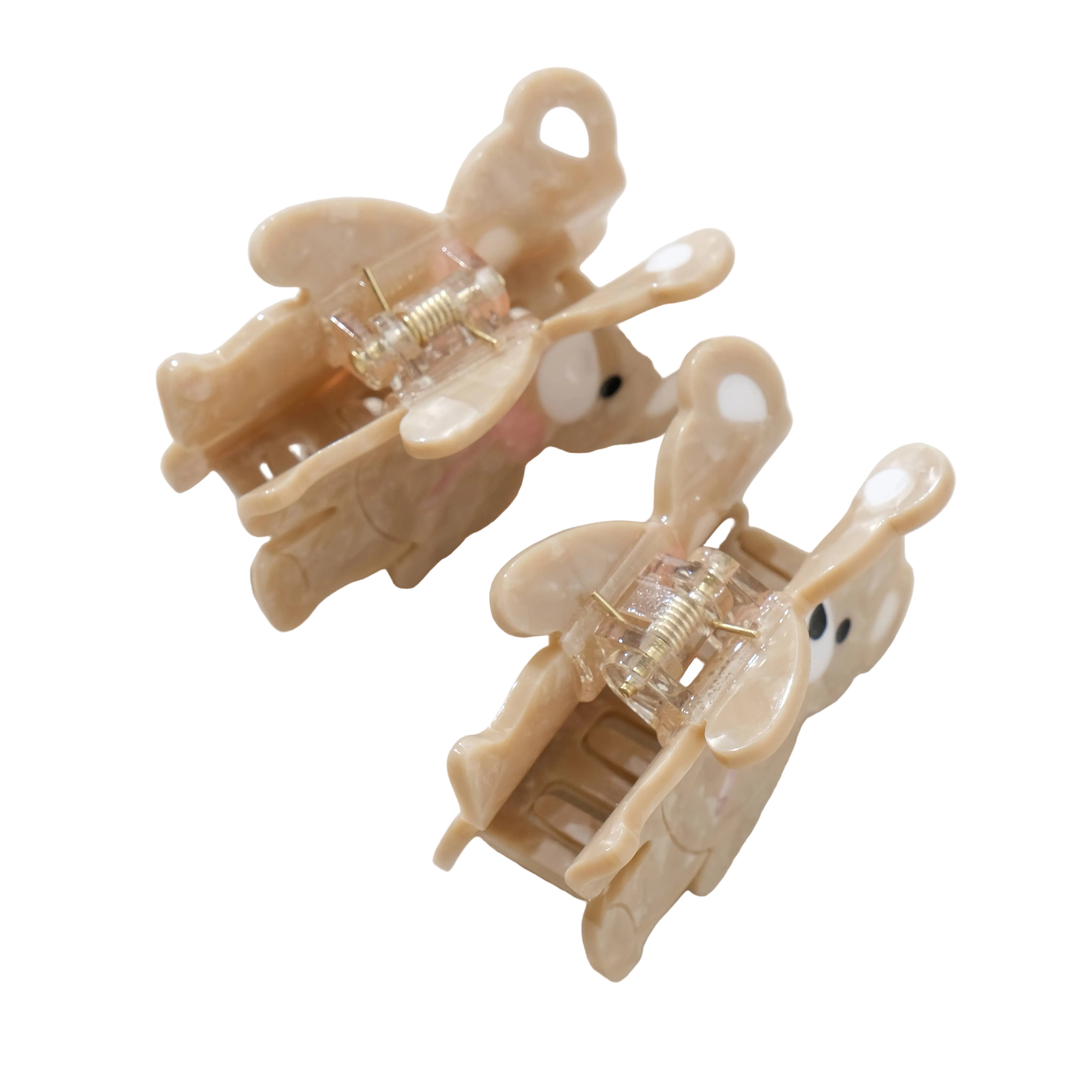 Two beige hair clips with clear plastic parts on a light gray background