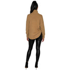A woman shown from the back wearing a camel-colored turtleneck sweater, black faux-leather leggings, and black high-heeled boots against a plain white background.