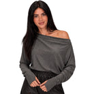 A woman modeling a dark gray off-the-shoulder long-sleeve knit top against a plain white background.