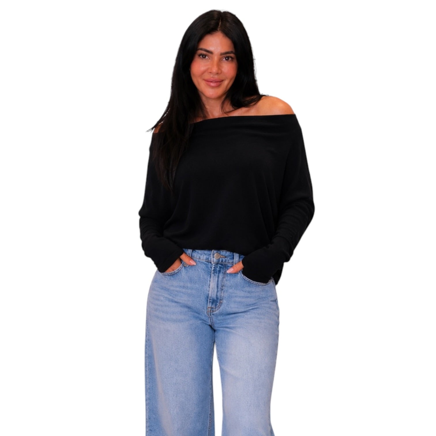 A woman modeling a black off-the-shoulder long-sleeve top paired with light-wash blue jeans, set against a plain white background.
