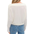 Person wearing a white long-sleeve top and blue jeans on a white background