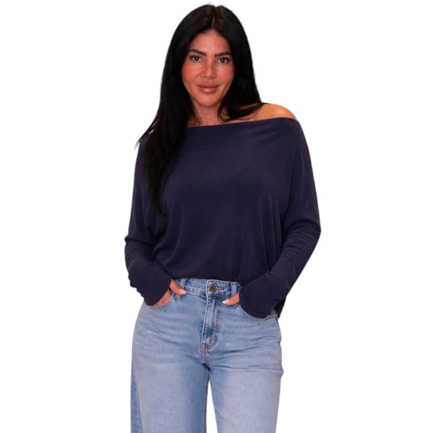 A woman modeling a dark navy off-the-shoulder long-sleeve top paired with light blue jeans, set against a plain white background.