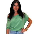 Woman wearing a green top and blue jeans on a white background
