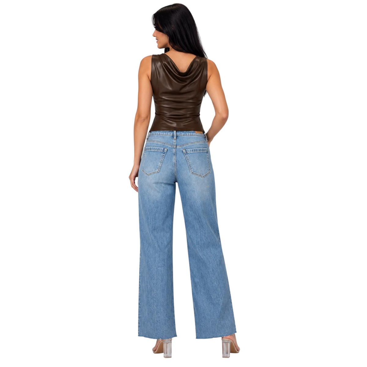 A woman shown from the back wearing a dark brown faux-leather cowl-neck sleeveless top and light-wash wide-leg blue jeans, standing against a plain white background.