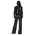 A woman shown from the back wearing a black sequined cropped jacket with long sleeves and black wide-leg faux-leather pants, photographed against a plain white background.