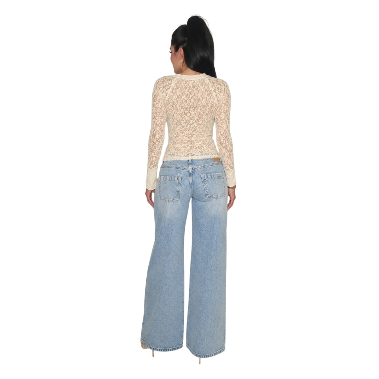 A woman shown from the back wearing a beige lace long-sleeve top and light blue wide-leg jeans, photographed against a plain white background.