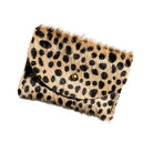 A small cowhide cardholder with a leopard print pattern, featuring black spots on a tan background with a gold snap button closure, shown on a plain white background.