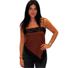 Woman wearing a brown top with lace details on a white background