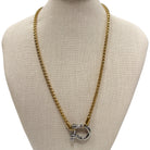 Gold chain necklace with a silver clasp on a mannequin bust.