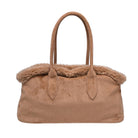 A tan suede handbag with a plush, fluffy shearling-style trim along the top edge and double top handles, shown against a plain white background.