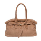 A tan suede handbag with a plush brown shearling-style lining and trim, featuring dual top handles, a front strap detail, and gold-tone hardware, shown against a plain white background.