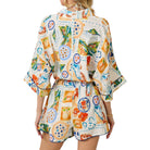 Woman wearing a colorful patterned outfit on a white background
