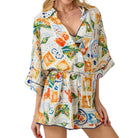 Woman wearing a colorful patterned romper outfit on a white background