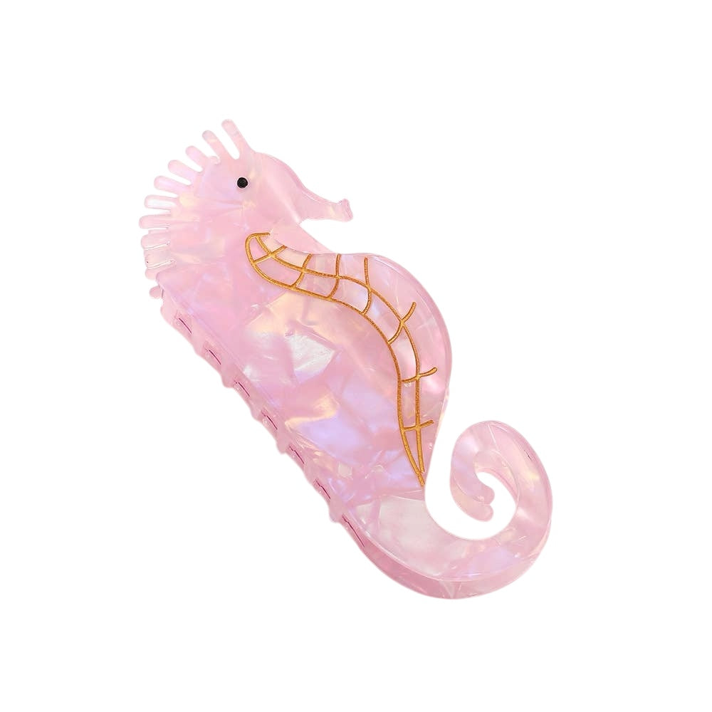 Pink seahorse-shaped hairbrush with gold accents on a white background