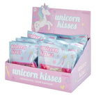 A pink cardboard display box filled with individually wrapped 'unicorn kisses' squeeze toys. The packaging features pastel blue and pink bags with unicorn illustrations and the words 'unicorn kisses' printed on them.