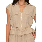 Beige sleeveless top with a zipper and drawstring waist on a white background