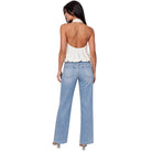 A woman shown from the back wearing a light blue wide-leg denim jeans and a white halter top, photographed against a solid white background.