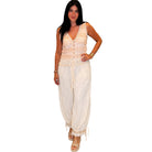Woman wearing a blush sleeveless top and high-waisted pants on a white background