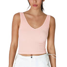 Woman wearing a pink ribbed tank top on a white background