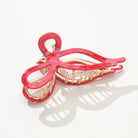 Red hair clip with gold accents on a white background