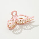 Pink hair clip with gold accents on a white background