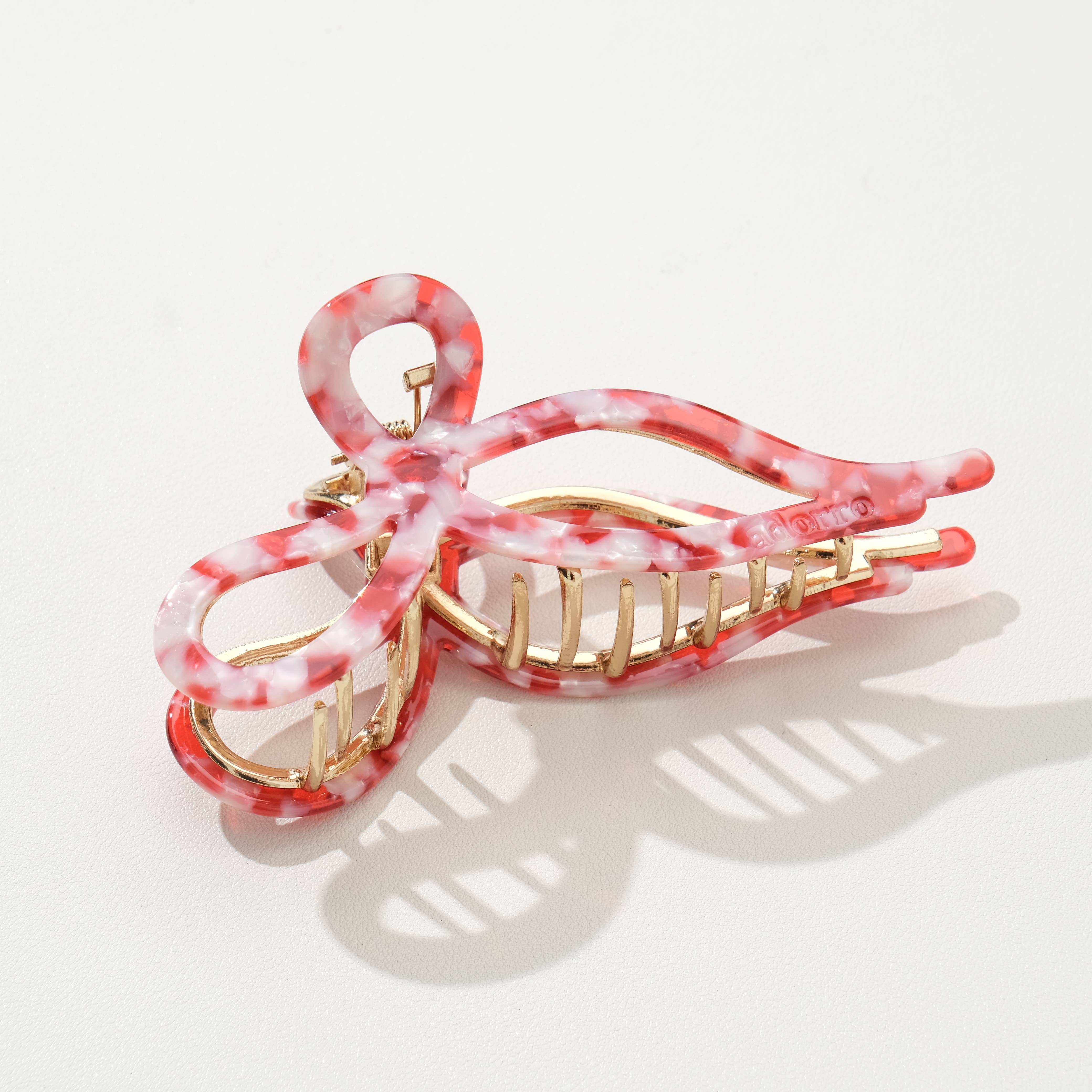 Pink and gold hair clip on a white background