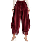 A pair of women's balloon-style velvet pants in deep burgundy, featuring a lace hem and elastic waistband, shown on a model from the back against a white background.