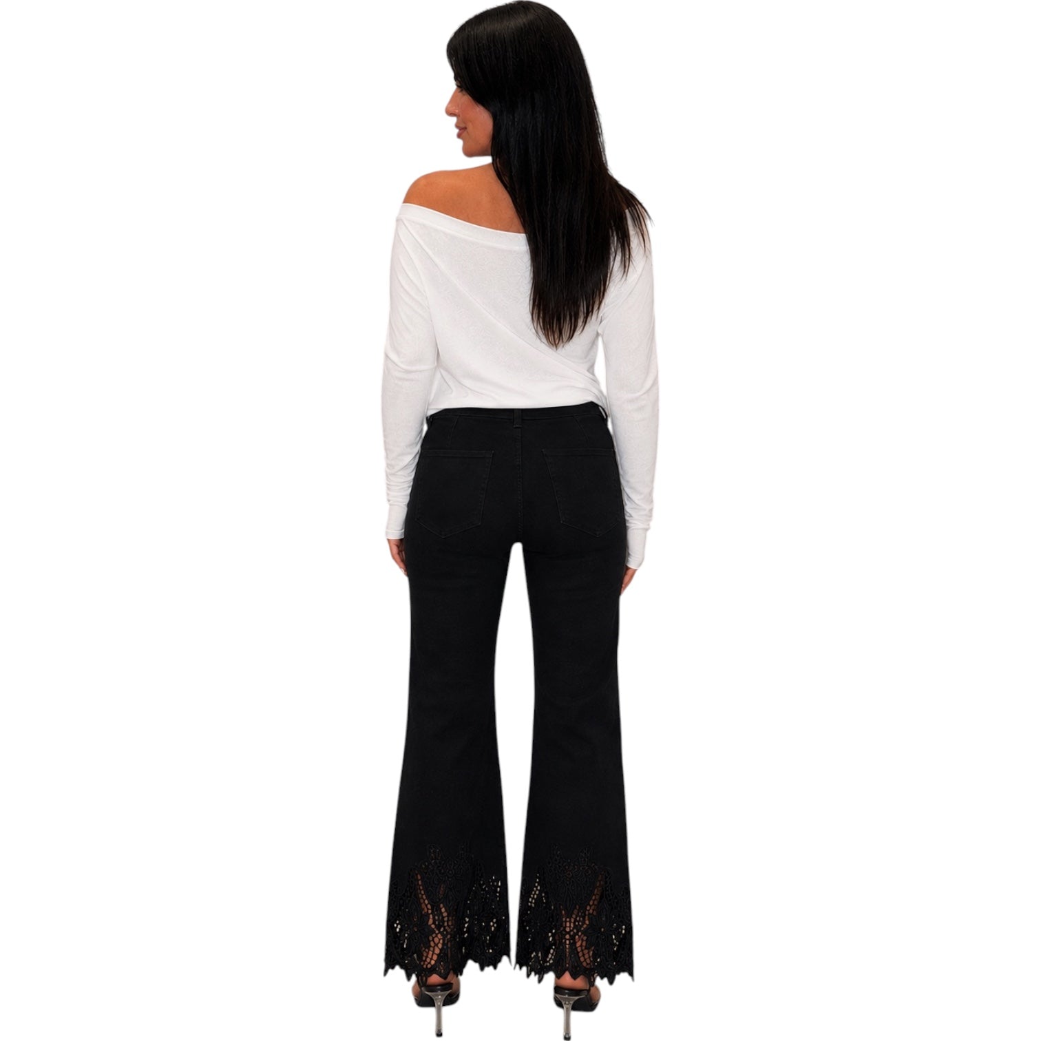 A woman shown from the back wearing a white off-the-shoulder long-sleeve top and black flared pants with lace detailing at the hem, against a plain white background.