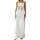 White lace top and wide-leg pants on a white background