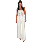 Woman wearing a white outfit with lace details on a white background