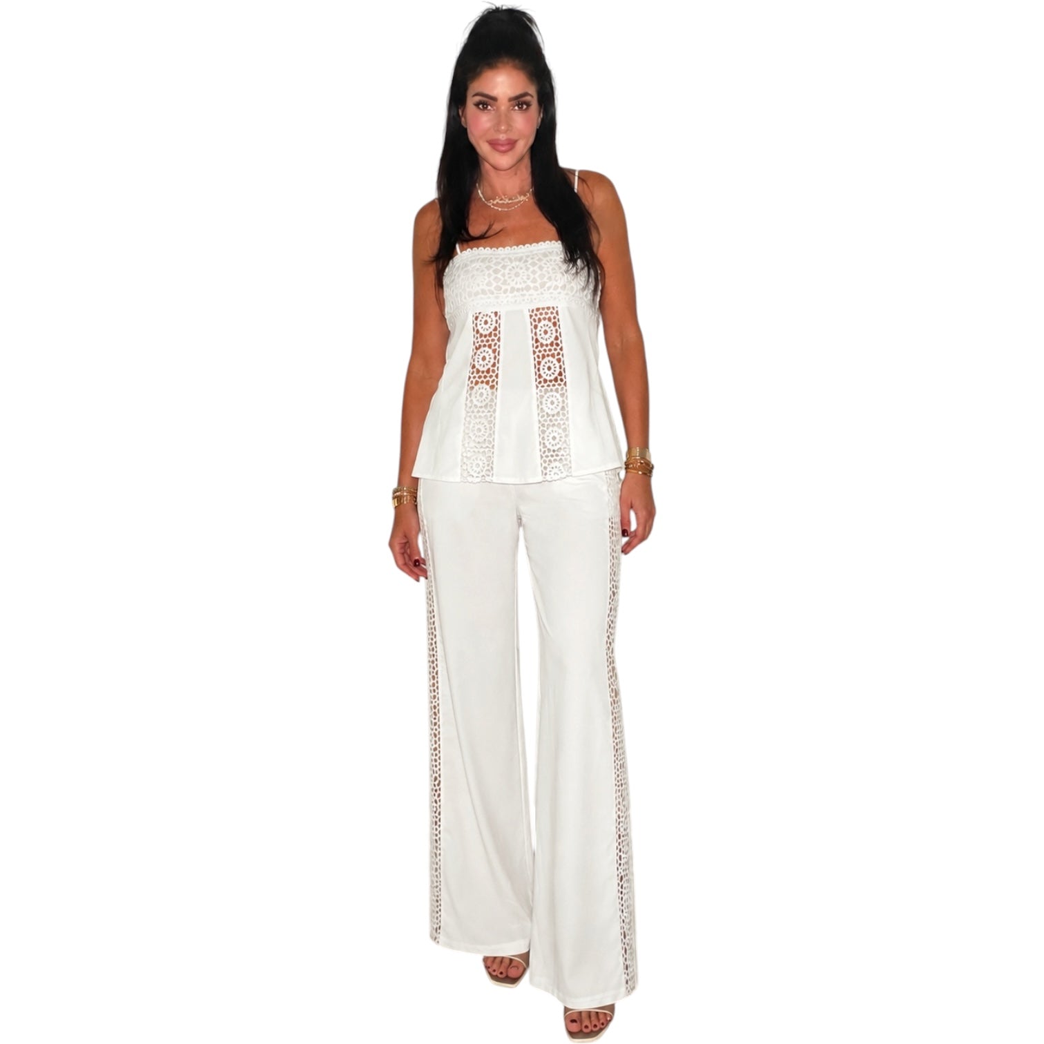 Woman wearing a white outfit with lace details on a white background
