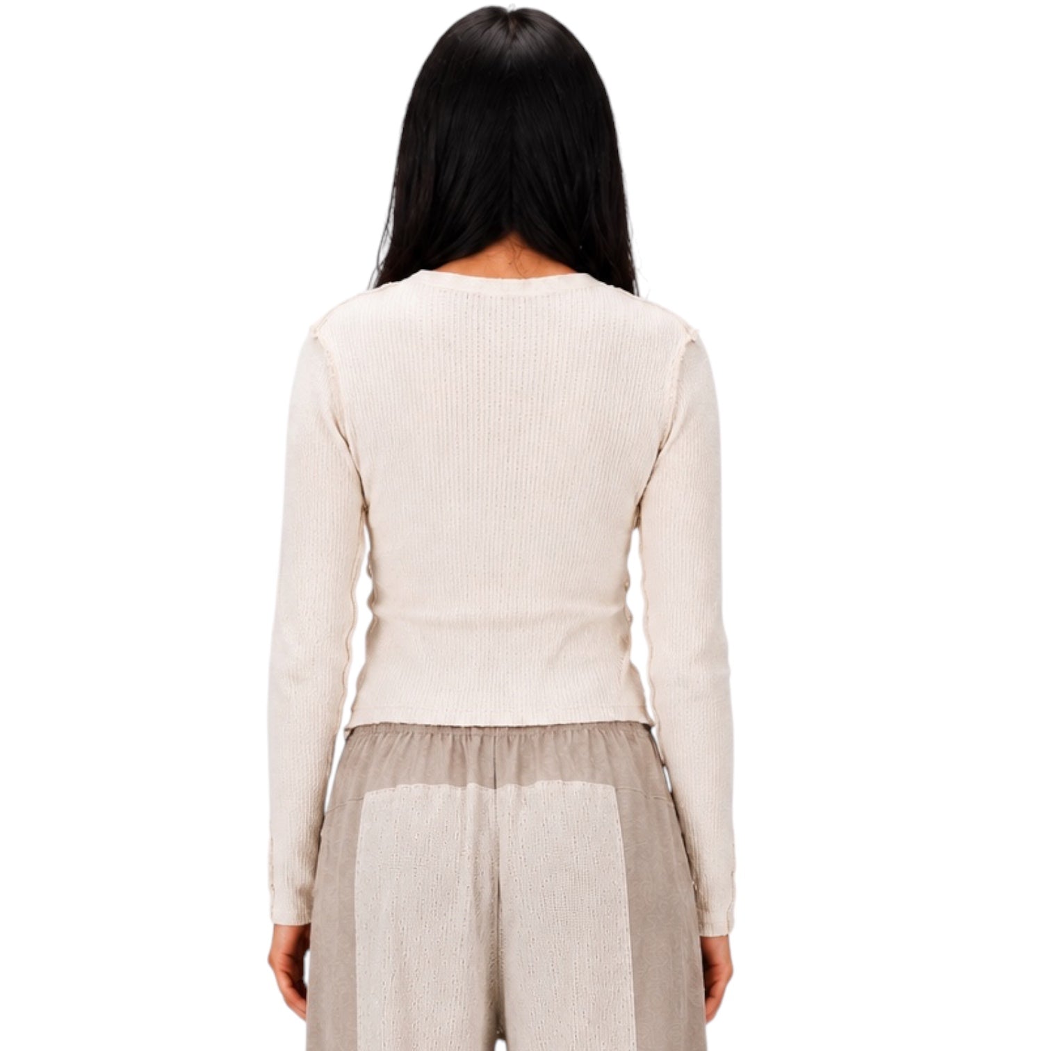 A woman shown from the back wearing a ribbed long-sleeve knit top in a light cream color and light beige textured pants, set against a plain white background.