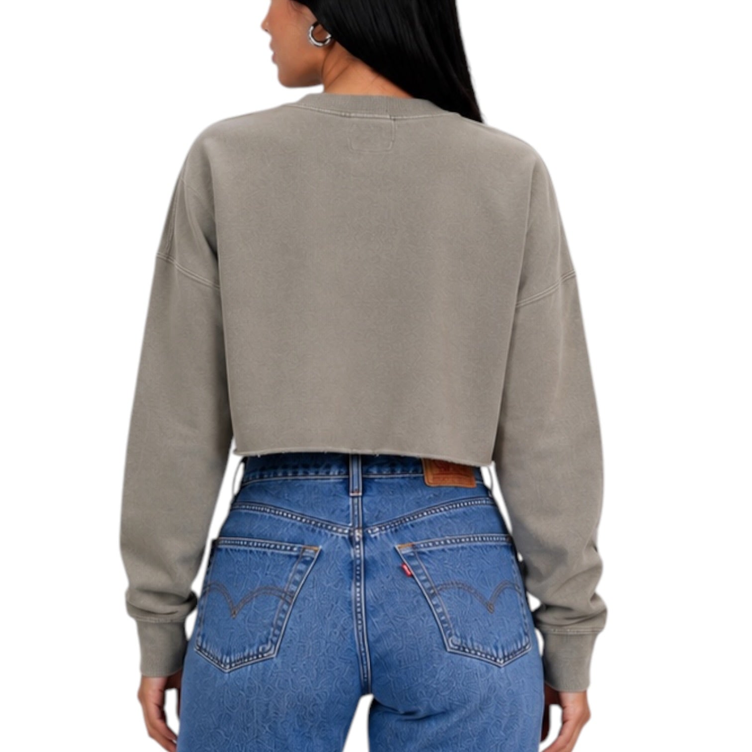 A woman shown from the back wearing a taupe gray cropped long-sleeve sweatshirt and blue jeans against a plain white background.