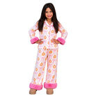 A young girl modeling a two-piece pajama set featuring an orange pumpkin and pink bow pattern on a white background, with pink faux-fur cuffs and hem, set against a plain white studio background.