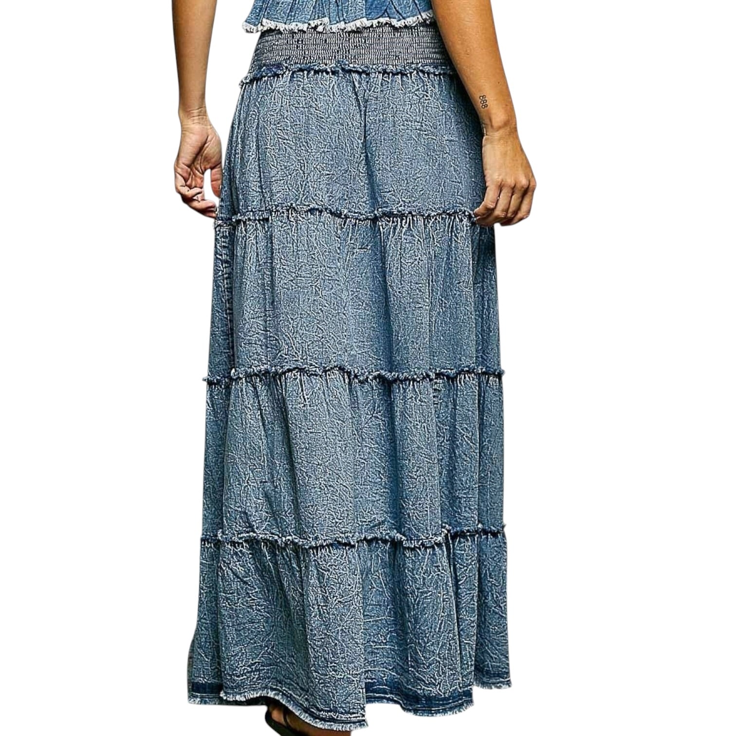 Denim tiered skirt worn by a person on a white background