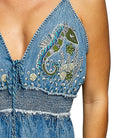 Denim dress with intricate embroidery on a white background