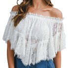 White lace off-shoulder top worn by a person on a white background