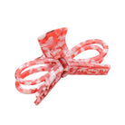 Three pink hair accessories with bow designs on a white background