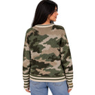 A woman shown from the back wearing a long-sleeve crewneck sweater with a green, brown, and beige camouflage pattern and striped ribbed trim, paired with blue jeans against a plain white background.