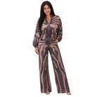 A woman modeling a matching two-piece jumpsuit set with a brown and beige zebra-like animal print. The set includes a long-sleeve zip-up top with a drawstring waist and matching wide-leg pants, shown against a plain white background.