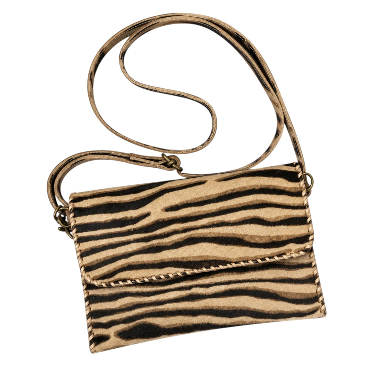 A small crossbody handbag with a zebra print pattern in beige and black, featuring a matching adjustable shoulder strap and gold-tone hardware, shown on a plain white background.