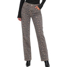 A person wearing straight-leg jeans with a brown and beige leopard print pattern, paired with a black long-sleeve top and black ankle boots, shown against a plain white background.
