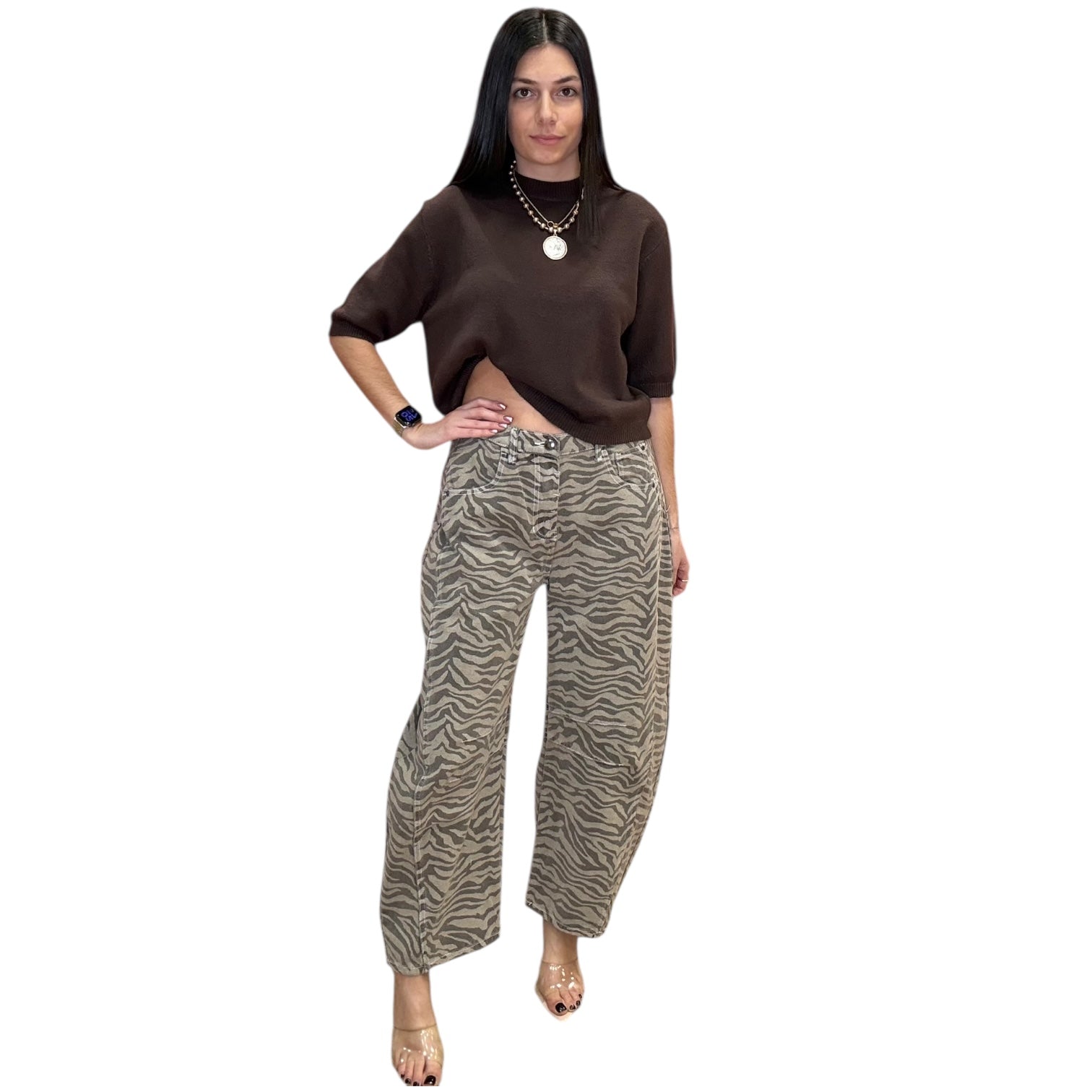 Woman wearing a brown top and zebra print pants on a white background