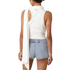 Person wearing a white sleeveless top and denim shorts on a white background