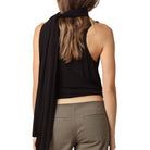 Woman wearing a black sleeveless top and brown pants on a white background
