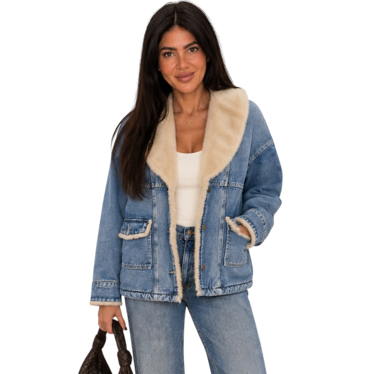 A woman modeling a light blue denim jacket with a thick cream-colored shearling lining on the collar, cuffs, and pockets, paired with blue jeans and a white top against a plain white background.