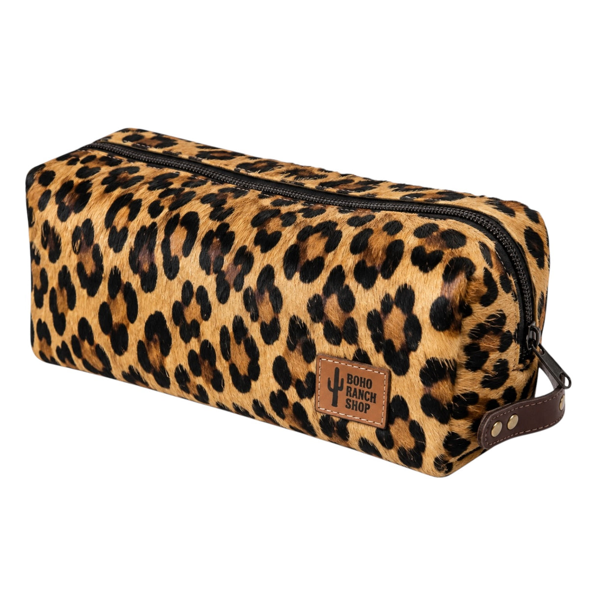 A leopard print faux fur pencil case with a brown leather brand patch and handle, shown on a plain white background.